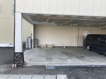 坂を登った店の裏口に駐車場があります。写真の車から左右に1台、さらに止めれます。