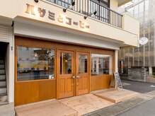 ハサミとコーヒーの雰囲気（向かって右側の扉が美容室、左側の扉がカフェとなっております。）