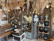 ヘアーアンドデザイン シェルハ(hair&design Shel-Ha)の雰囲気（ドライフラワーと、壁一面の木材が印象的なセット面。）