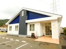 美容室 彩華の雰囲気(三角屋根の白と青の建物です!駐車場はお店の前にあります。)