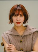 オレンジヘアで無造作に動かすボブ
