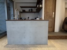 ヨハク(YOHAC.)の雰囲気(モルタルとアンティーク調の木材を使ったキッチンスペース。)