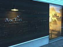 アオイ トリ ヘア デザイン(Aoi Tori Hair Design)の雰囲気（通り沿いに目を引く、白い外観に木の扉。）