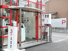 榮美容室 本店の雰囲気（店舗の横と裏に駐車場完備。赤い格子状の縦長の店舗が目印です！）