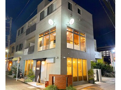 夜の外観/コンクリート打ち放し新築ビル「At.」の丸看板が目印！