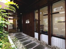 ヘアースタジアム ボブ 寝屋川公園駅店(Hair Stadium BOB)の雰囲気（情緒ある石畳の小道を歩いて、木の温もりを感じるサロン内へ…）