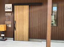 大きな木の扉と黄色いポストが目印