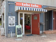 トベトベ(tobe tobe)の雰囲気（オレンジの看板とドア、ブルーのストライプの外観が目印です。）