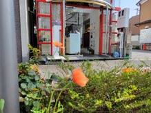 榮美容室 本店の雰囲気（店舗の横と裏に駐車場完備。赤い格子状の縦長の店舗が目印です！）