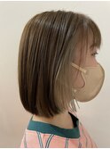 柔らかベージュの前上がりボブスタイル