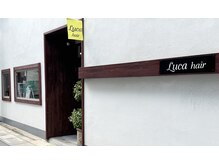 ルカヘアー(Luca hair)の雰囲気（黄色のLuca hair  のフラッグが有り、入り口にはガジュマルの木）