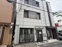 スピン(SPiN)の雰囲気(外観:コインパーキングの隣のグレーの建物・階段で2階です。)