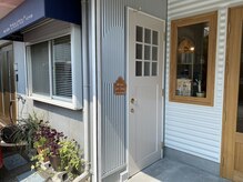 店舗前駐車スペースあり。青いテント横の白い扉が入口です。