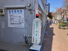 亀有整体院の赤い回転灯看板が目印です。
