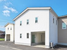 【白い建物に緑の玄関】が目印♪目の前にご駐車いただけます。