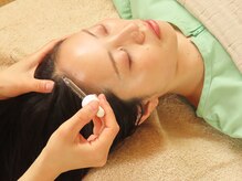 NAOホリスティック鍼灸サロンの雰囲気（フラワーエッセンスを使用して頭皮をマッサージしていきます）