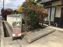 オリジンの雰囲気（玄関前の看板と駐車場）