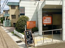 堀田整骨院の雰囲気（当院外観です。オレンジの看板が目印です。）
