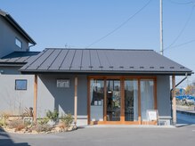 ヒント アイ(hint eye)の雰囲気（グレーの外壁に木枠のドアが目印です）