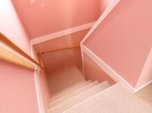 可愛いピンク色の階段を上がって施術ルームに向かいます。