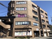 近鉄生駒駅より徒歩３分。茶色のビルの５階に店舗がございます。