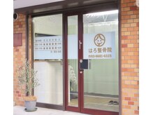 はろ整骨院の雰囲気（レンガ外観ウッド調の玄関と八と六のスマイルマークが目印です。）