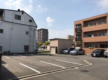 写真左の2番が駐車場です。お店は右の茶色のマンション102号です