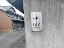 ISYネイルサロンの雰囲気（コンクリートの外壁にメタリックの看板が目印です。）