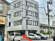 「杉岡モータース」さん隣。矢印の奥に入口、駐車場、駐輪場です