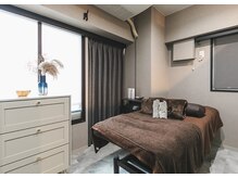 黒とグレーを基調とした大人な雰囲気の個室施術ルーム。