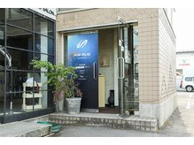 建物正面右手側が入口になります。階段を上りご来店ください。