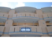 めがね屋さんがある茶色のアパート205号室です。お待ちしてます