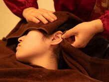 ドライヘッドスパQの雰囲気（耳を引っ張ることで筋膜が緩み、血流アップ。）