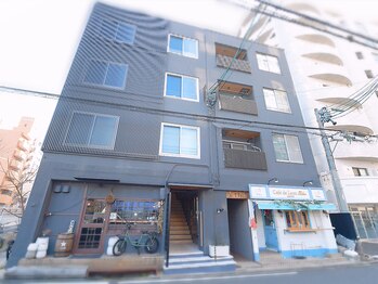 サロン ねこ/黒色の4階建てマンションです。