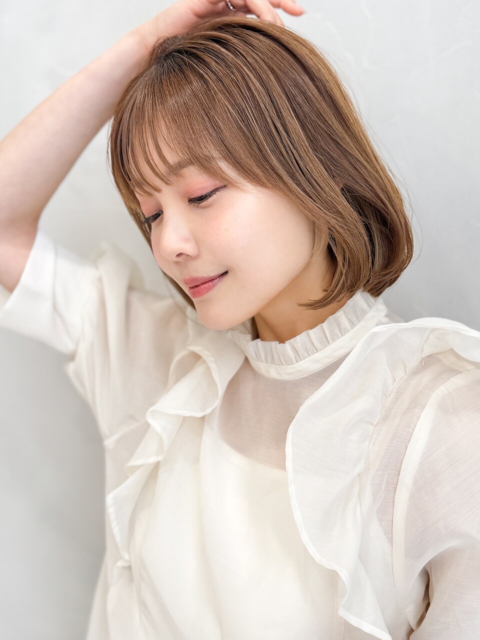 イメチェン厚めバング耳かけフォギーベージュ毛先パーマミディ